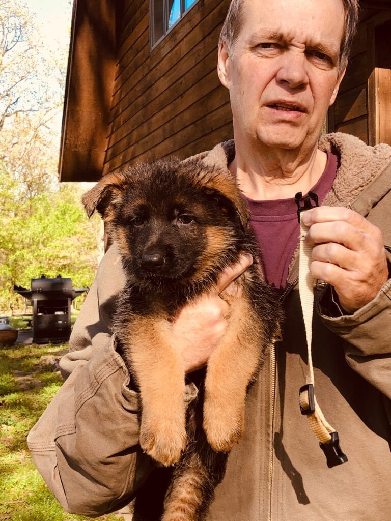 A man holding a puppy in his arms.